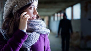 female on the phone with stalker in the background