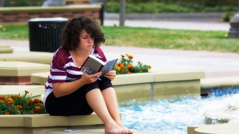student reading near fountain