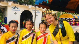 Sierra Drummond in Thailand posing with three little girls