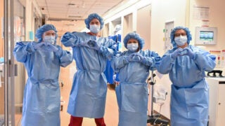 Frontline workers posing making heart shape with their hands