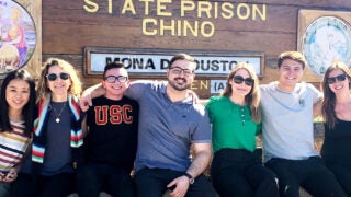 Students and faculty participating in the USC Dornsife Prison Education Project pose outside Chino State Prison.