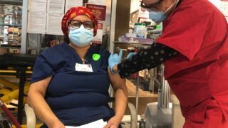 Maria Saravia, a Keck Medicine of USC environmental services specialist, receives the vaccine.