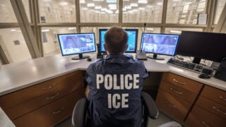 ICE officer monitoring computer screens