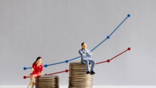 Male and female figures sitting on top of quarters graphic