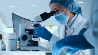 researcher looking into microscope