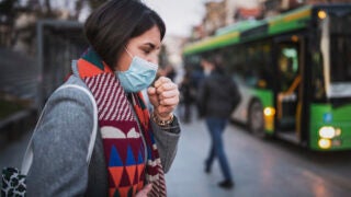 woman wearing a mask and coughing