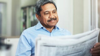 elderly man reading the morning paper