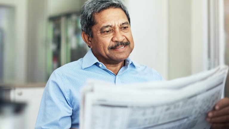 elderly man reading the morning paper