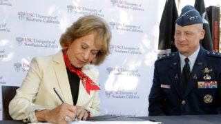 Carol L Folt signing document