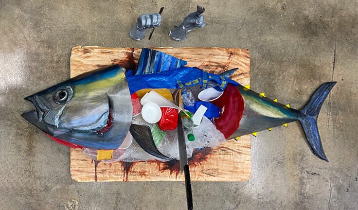 Scale tuna sculpture on a chopping board, composed out of recyclable, unrecyclable, and combustible materials