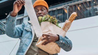 individual looking shocked at grocery receipt