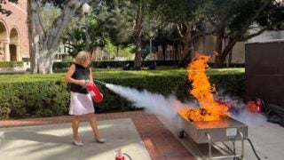 Carol Folt putting out a fire