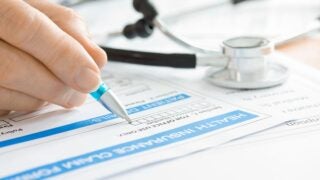 person filling out health insurance form