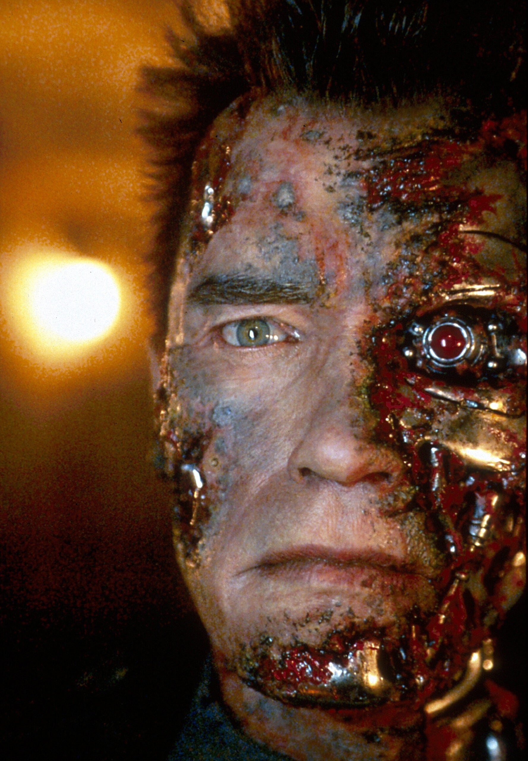 Terminator face of Arnold Schwarzenegger covering part of the metal face of the robot.