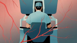 A surgeon sitting at a robotic system with red veins all round.