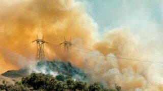 Smoke from fires on top of a mountain with power lines
