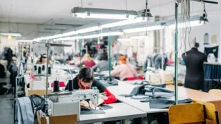 Woman using sewing machine in a garment shop