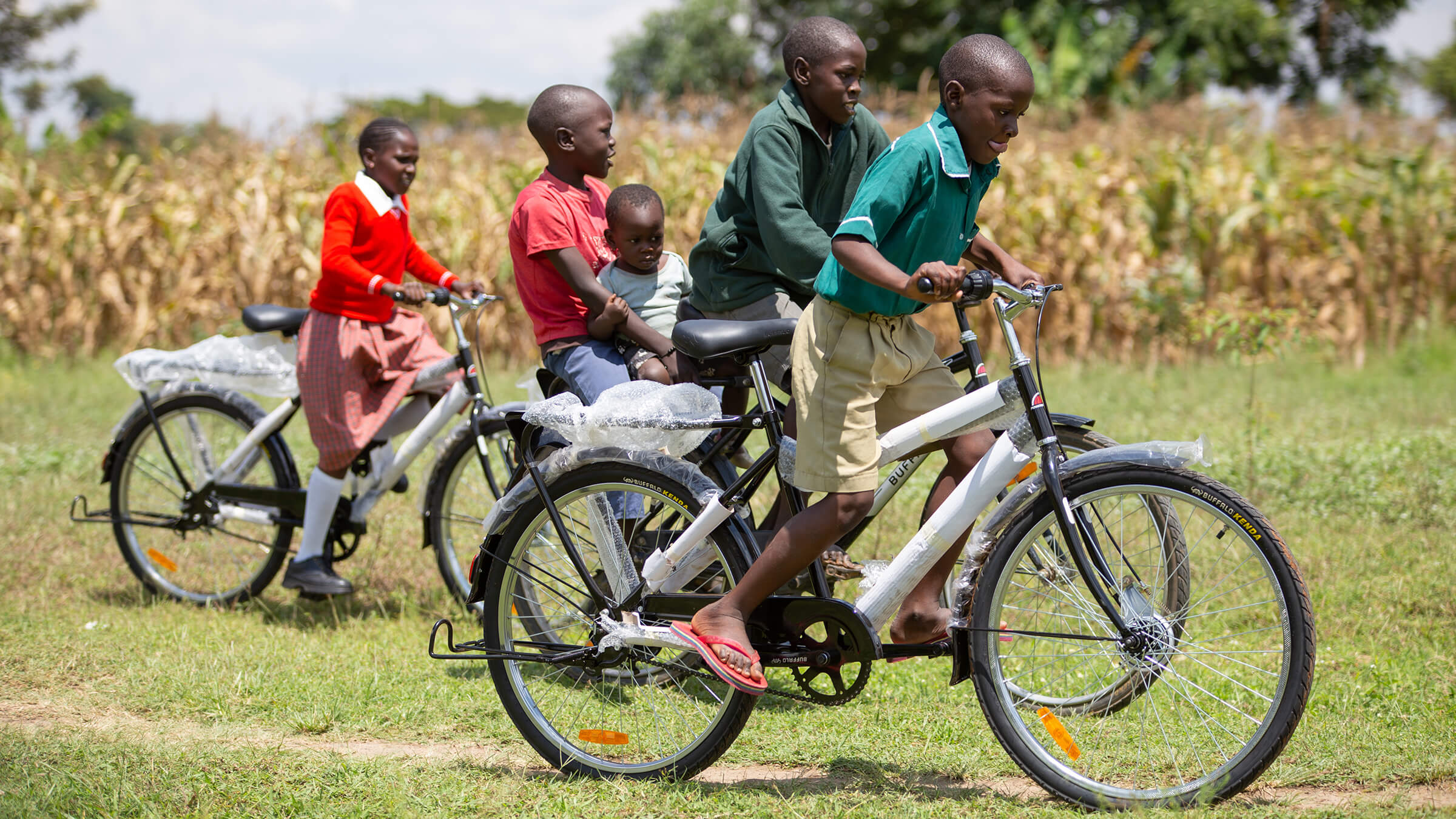 A gorup of students in Kenya race their new bikes.