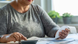 Woman reviewing a receipt with a calculator