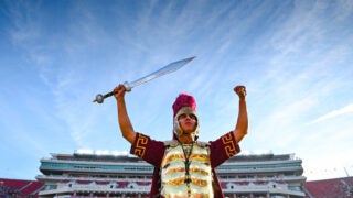 A USC drum major standing alone on the field.