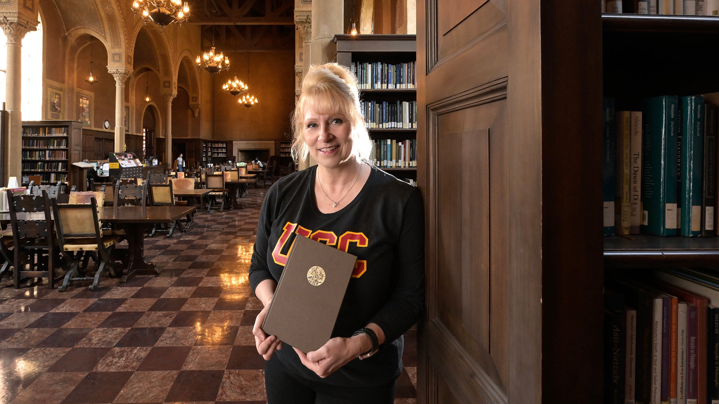 Melissa L. Miller head, Hoose library of philosophy with her favorite book Dr. Flewlling &amp;The Hoose Library “Life and Letters of a Man and an Institution” by Wallace Nethery, Oct. 7, 2024.(USC Photo/Gus Ruelas)