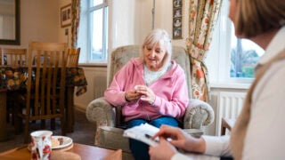 Older woman being visited in her living room