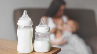 Baby bottles with nursing mother and child