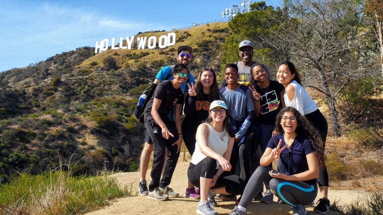 Faculty in residence plan group activities for students and welcome them into their families’ daily lives. Professor Broderick Leaks (right, back row) included his son Maxwell (center, second row) in this 2020 hike to the Hollywood sign. (Photo/Courtesy of Broderick Leaks)