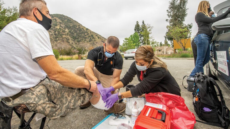 Street Medicine team members help homeless person