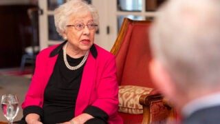 Dorothy Wright Nelson sitting at a table interacting with a colleague
