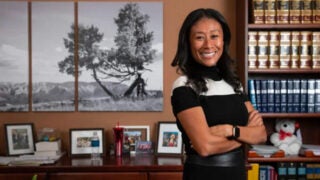 Patricia Thompson Lee smiling in an office with her arms folded