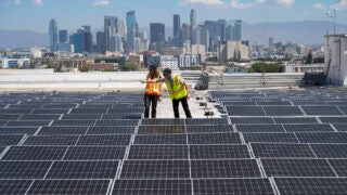 Zelinda Welch and Campbell Odening inspect solar panels on CAL roof