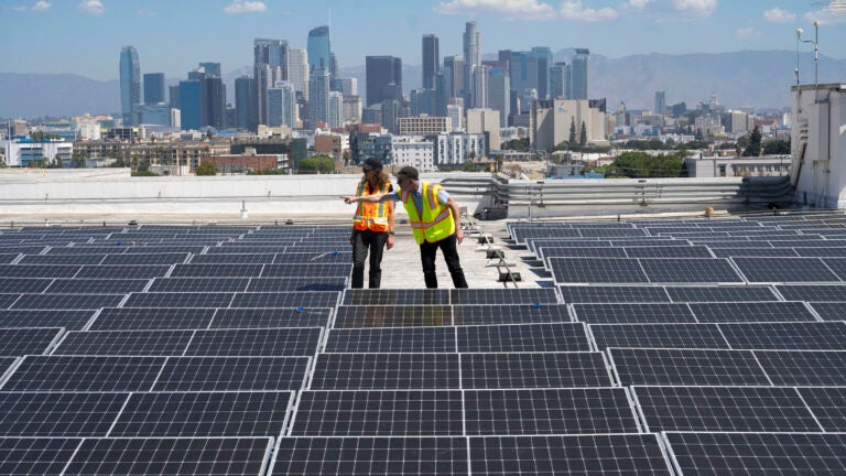 Zelinda Welch and Campbell Odening inspect solar panels on CAL roof