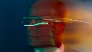 La Mer Walker, wearing glasses and turning his head to look at the camera