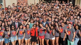 Carol Folt and McCarthy Honors Residential College students wearing dark gray shirts and posing for a group photo during move-in day
