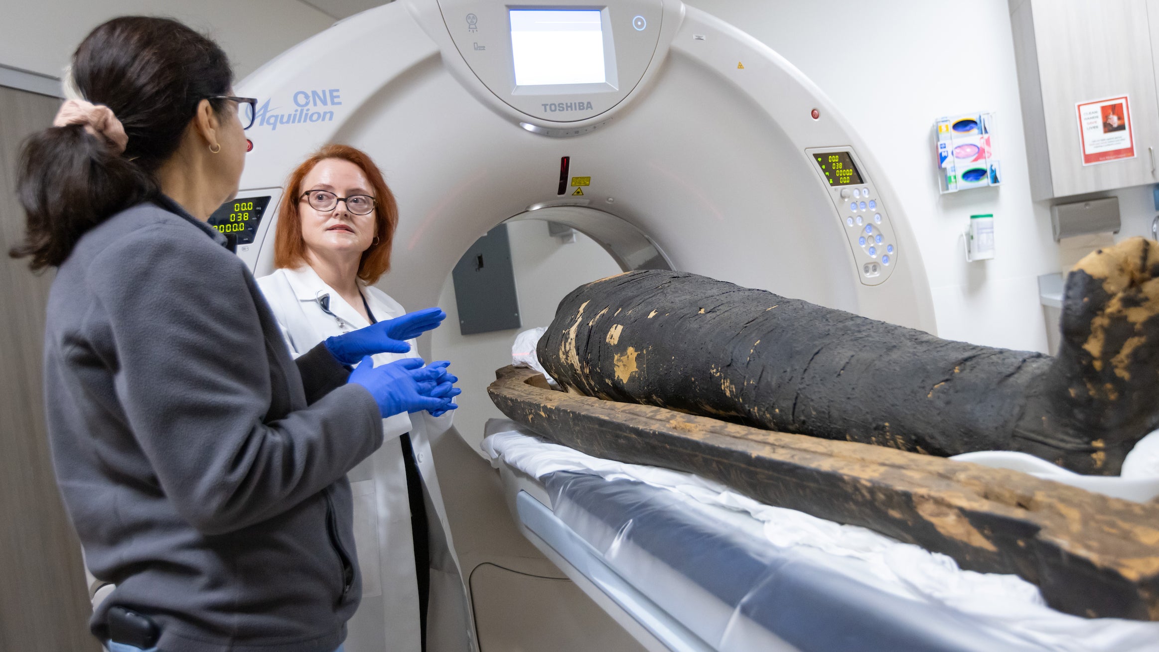 Diane Perlov (left), senior vice president for special projects at the California Science Center, and Summer Decker (right) examine ancient Egyptian mummy Nes-Hor. (USC Photo/Richard Carrrasco)