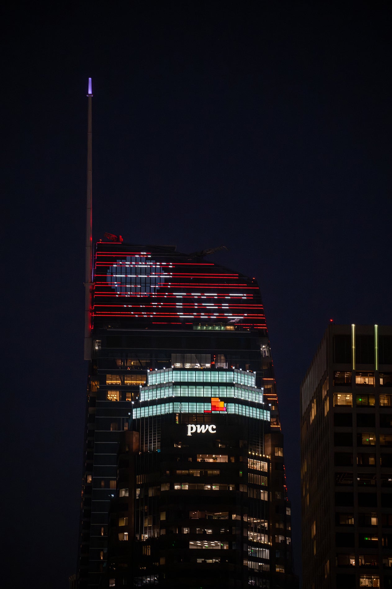 A skyscraper is illuminated with the USC logo